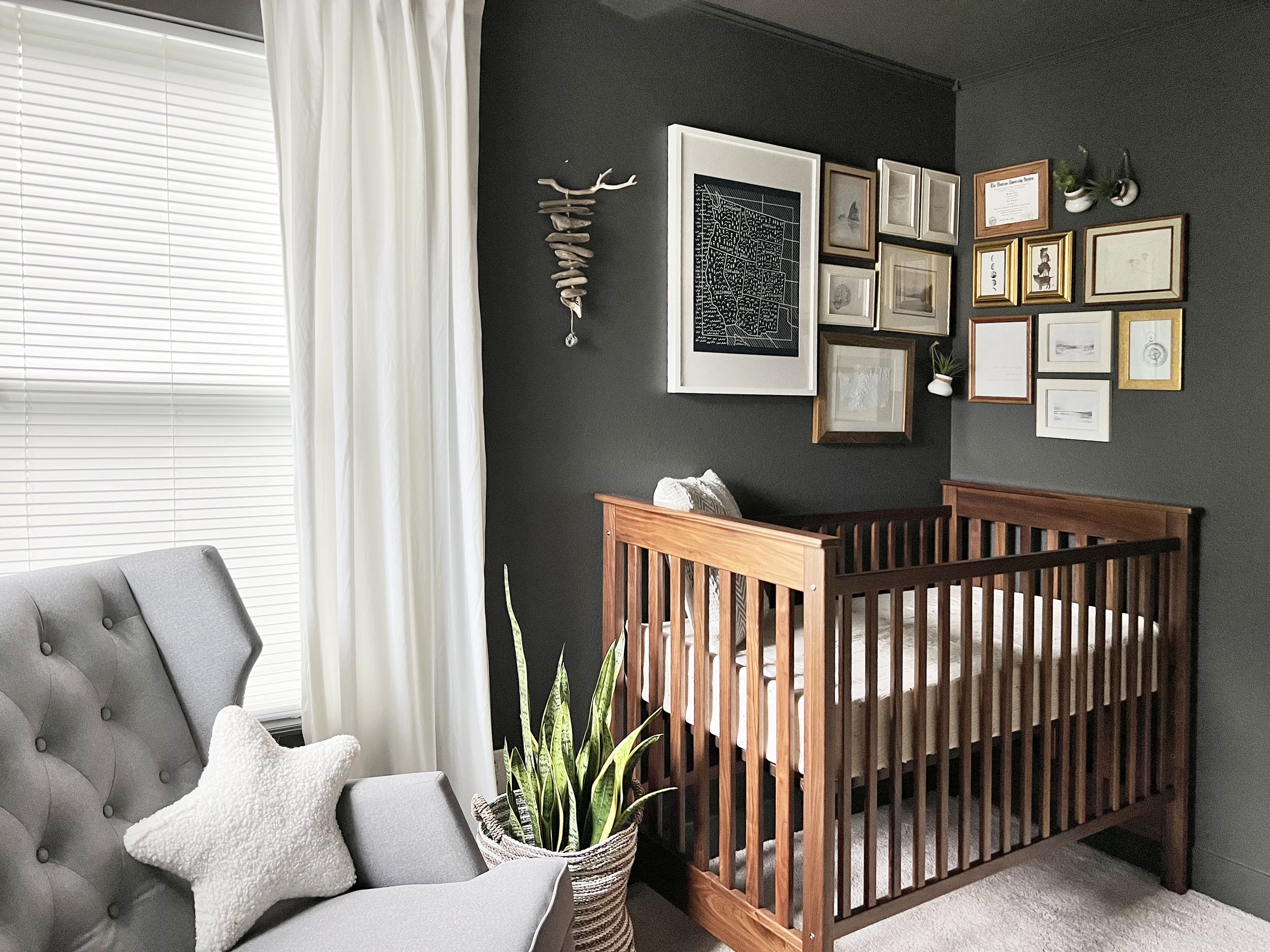 Designing a baby boy nursery, corner gallery wall. walnut crib, dark nursery, cozy nursery